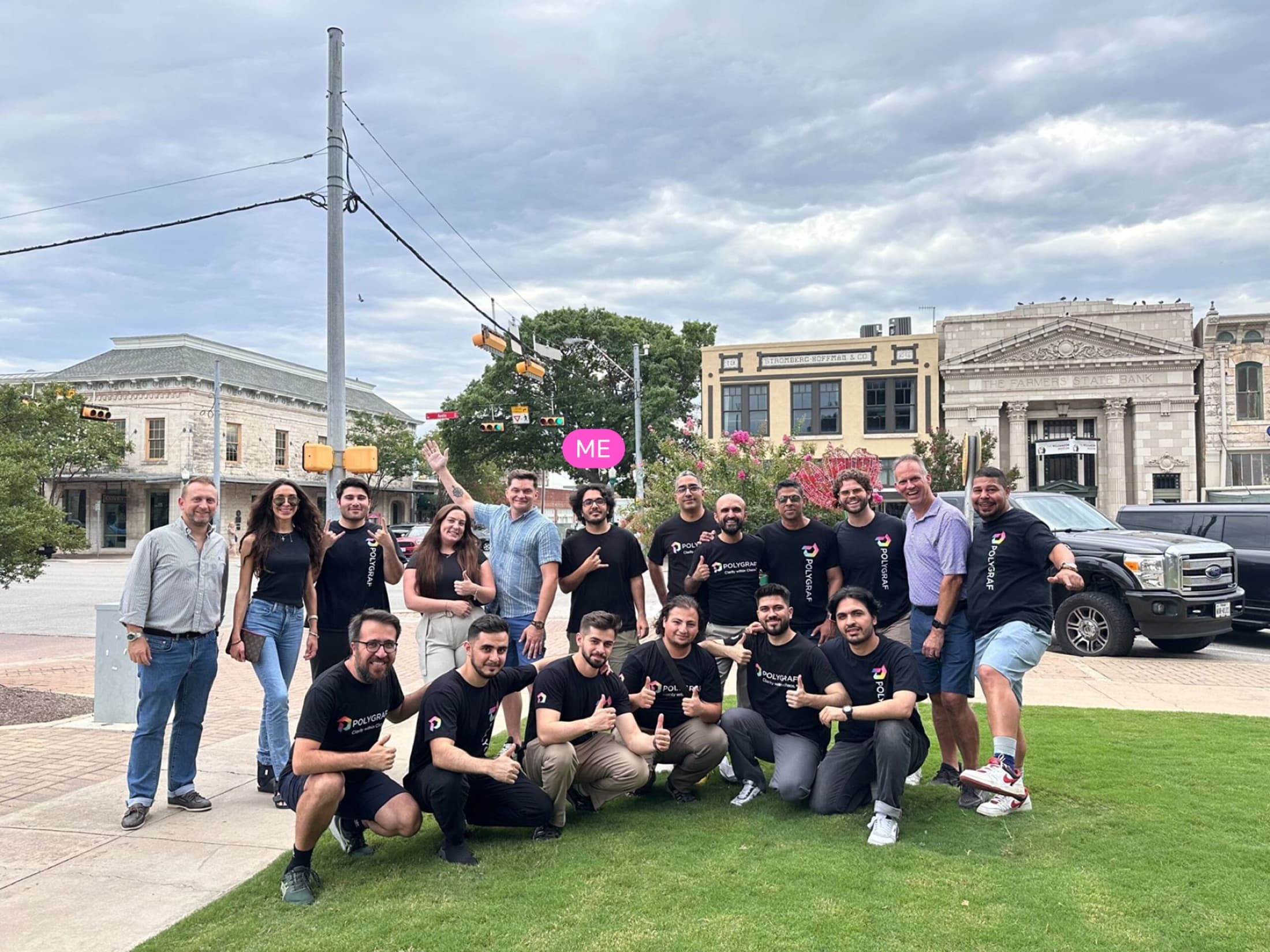 Polygraf team posing outdoors in front of historic downtown storefronts